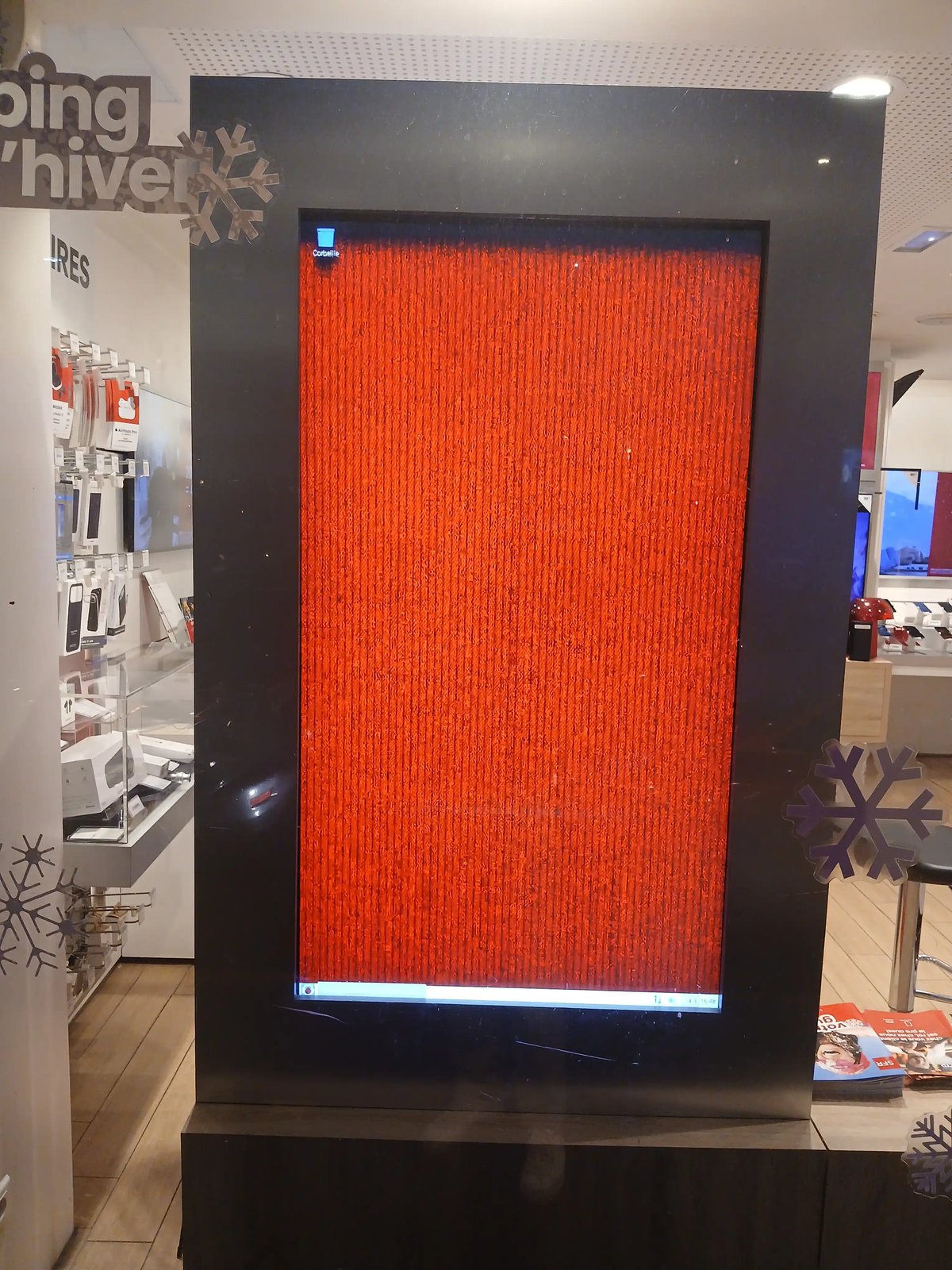 Un écran d'affichage montrant un bureau Windows avec un fond d'écran rouge