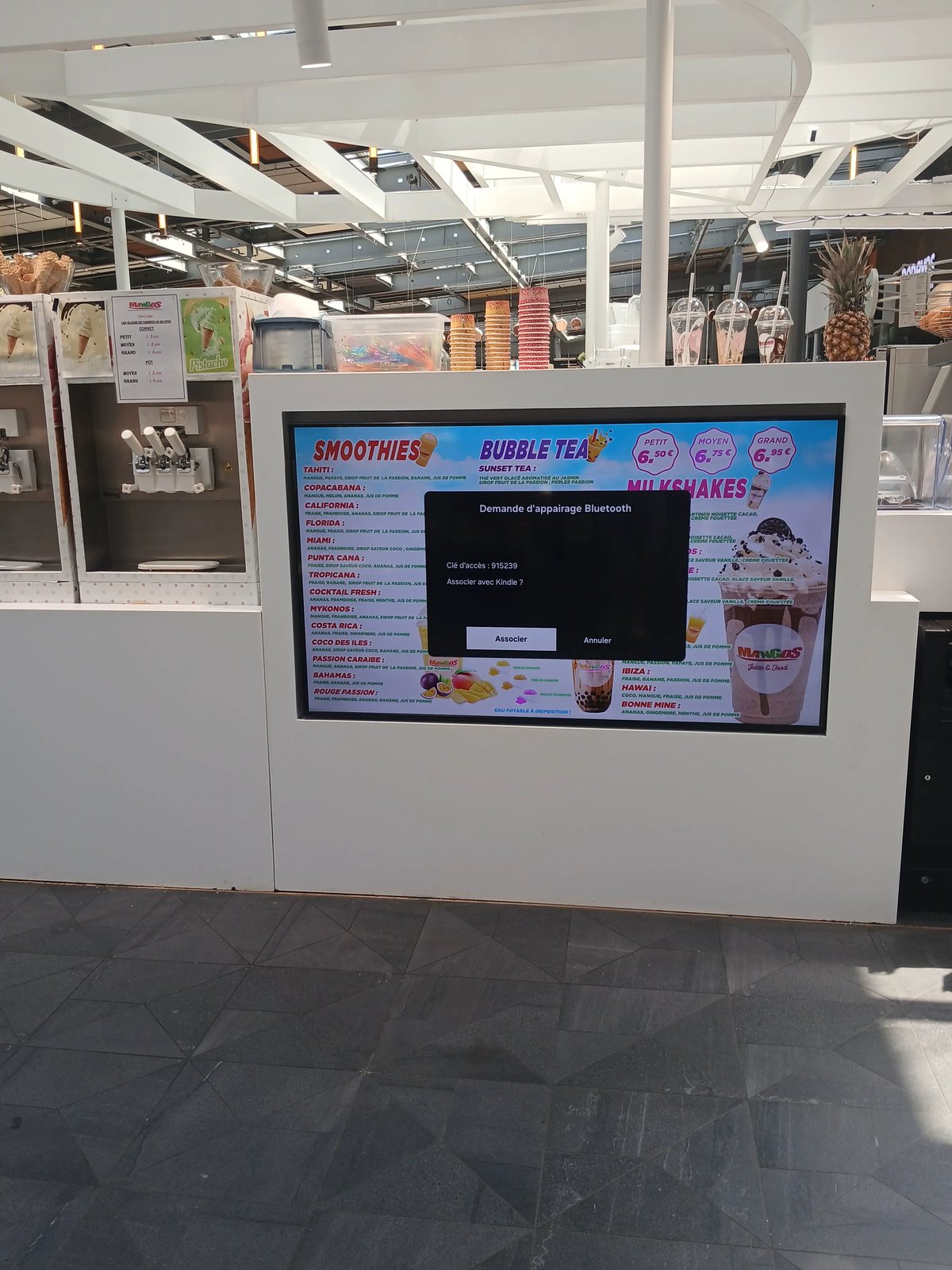 Un écran montrant le menu d'une boutique de jus de fruits avec un menu d'appairage bluetooth par-dessus