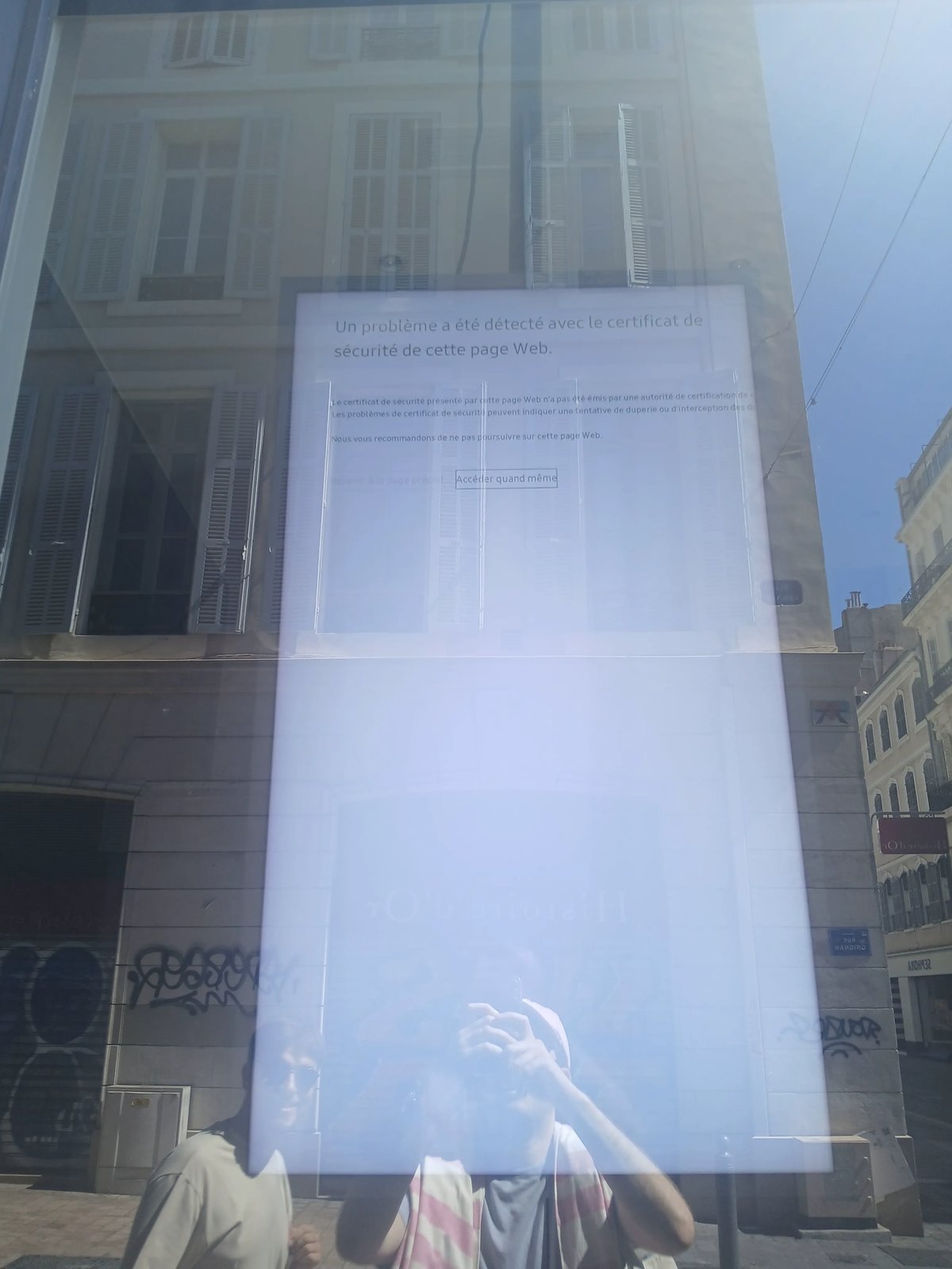 Un écran derrière une vitrine montrant une alerte de sécurité dans un navigateur