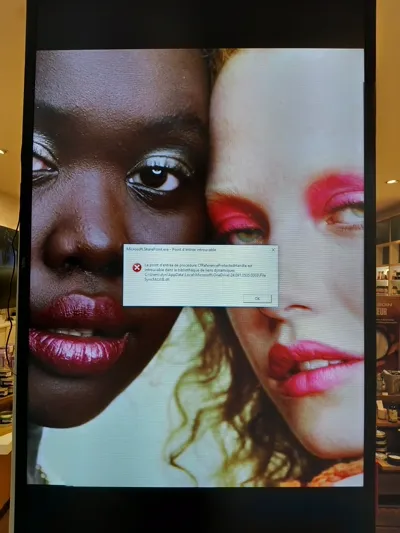 Un écran d'affichage montrant deux visages de mannequins et un message d'erreur Windows