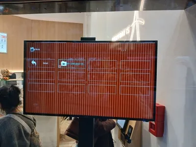 Un écran public montrant un menu de sélection de contenu média