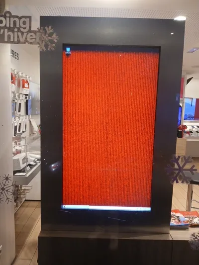 Un écran d'affichage montrant un bureau Windows avec un fond d'écran rouge